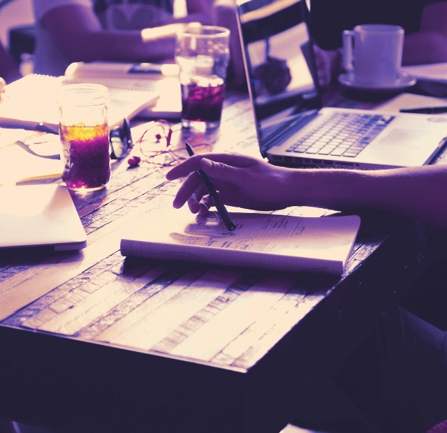 experience lab workshops und vorträge frÆn Notizbücher, Getränke, Laptop auf Tisch und Hände, die schreiben