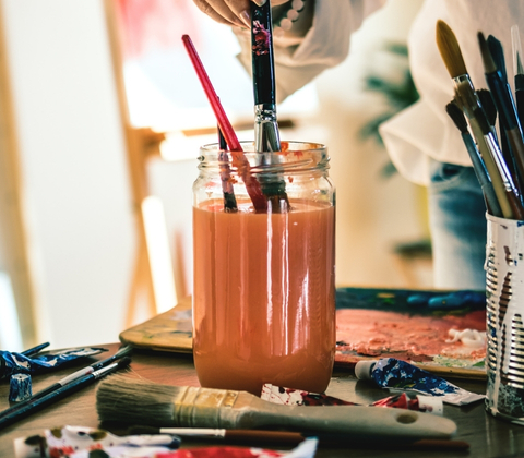 FRÆN Künstlerin Glas mit Pinselwasser und Pinseln