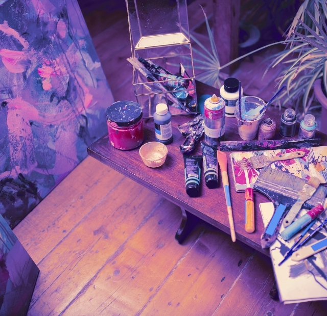 Kreativformate FRÆN Events No Signal Club, Kreativevents Malutensililen auf Tisch umgeben von Pflanzen und Leinwand