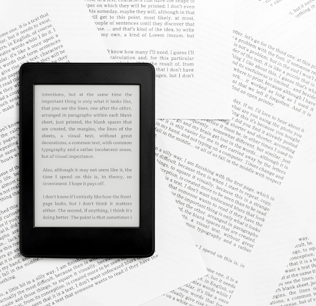 Papier mit Schrift bedruckt auf dem ein Tablet liegt mit einem geöffneten Schriftdokument